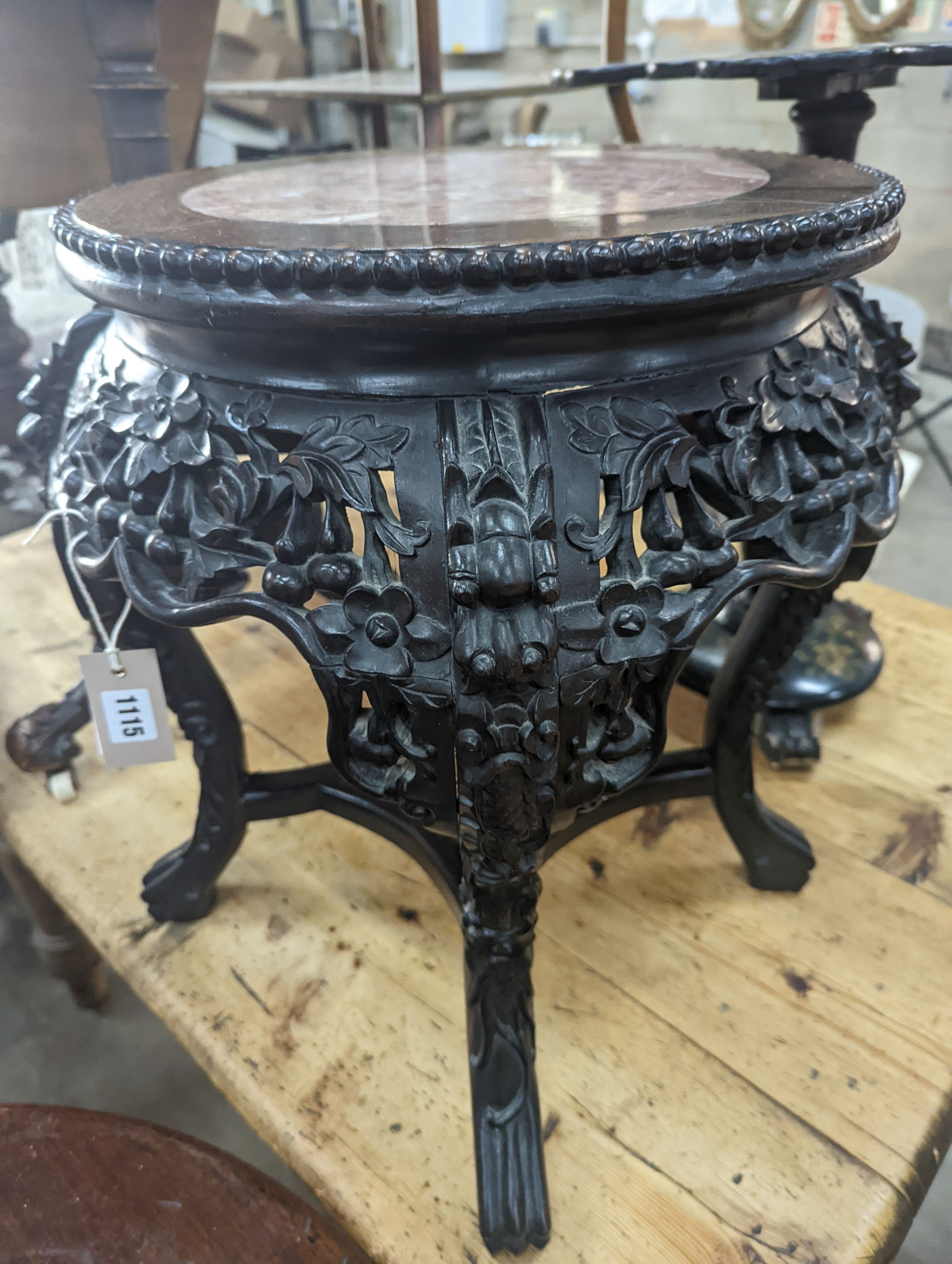 A 19th century Chinese carved hardwood jardiniere stand, with a rouge marble inset top, diameter 46cm, height 50cm